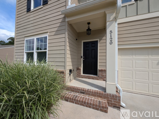 A house numbered 5120 with a black door and a white garage door.