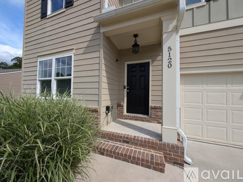 A house numbered 5120 with a black door and a white garage door.
