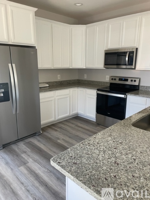 A kitchen with a granite counter top and stainless steel appliances.