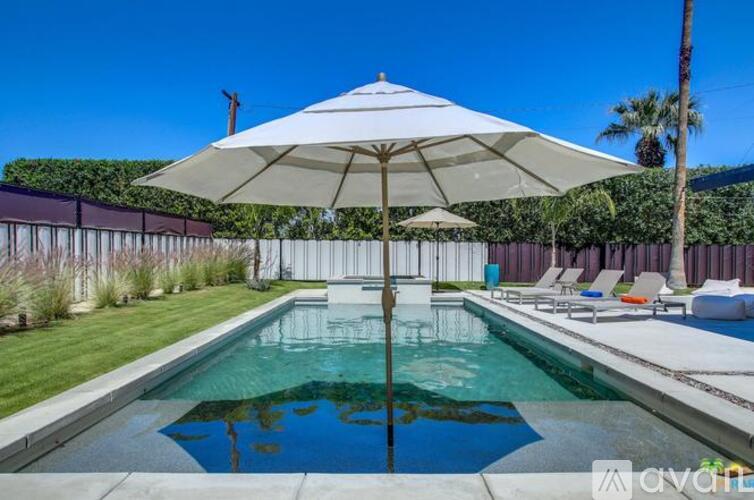 A pool with a white umbrella in the foreground.