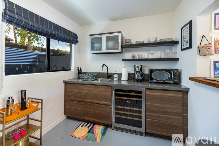 A kitchen with a wooden cabinet and a microwave above it.
