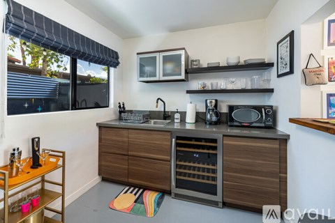 A kitchen with a wooden cabinet and a microwave above it.