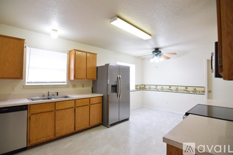A kitchen with wooden cabinets and a refrigerator.