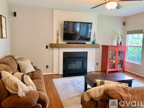 A living room with a fireplace and a television on the wall.