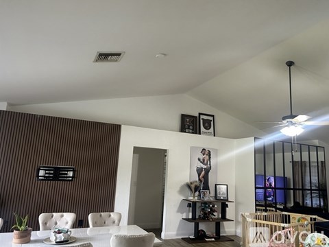 A living room with a white couch and a brown striped wall.