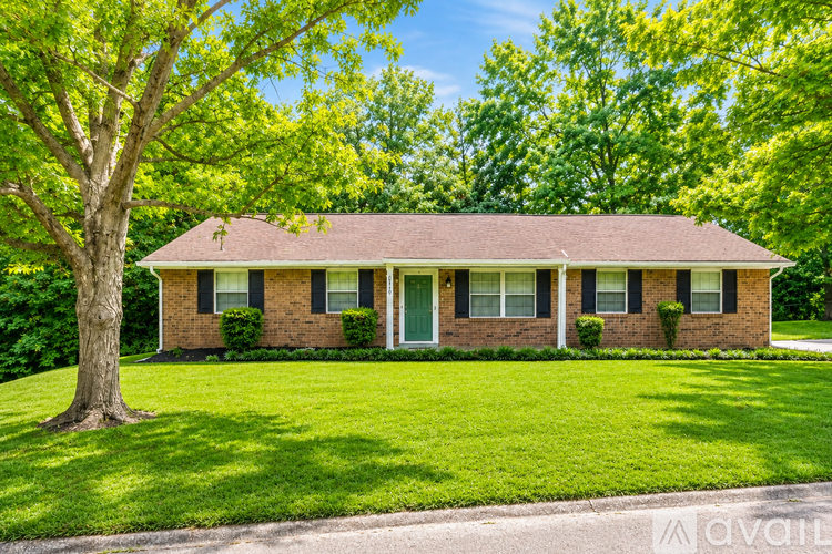 A house with a red roof and green trees in the background.