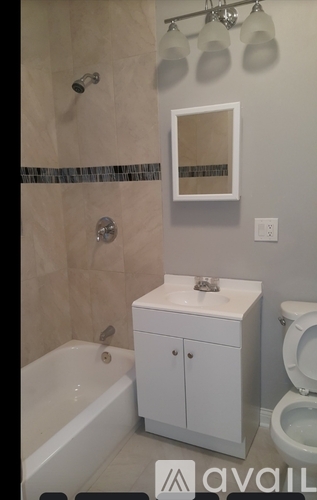 A white bathroom with a tub, toilet, and sink.
