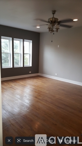 A room with a ceiling fan and wooden flooring.