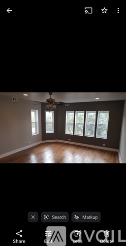 A room with wooden flooring and a chandelier.