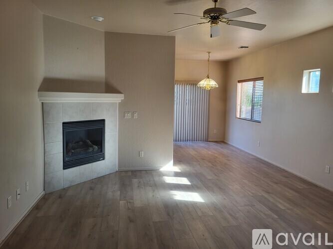 A living room with a fireplace and a ceiling fan.