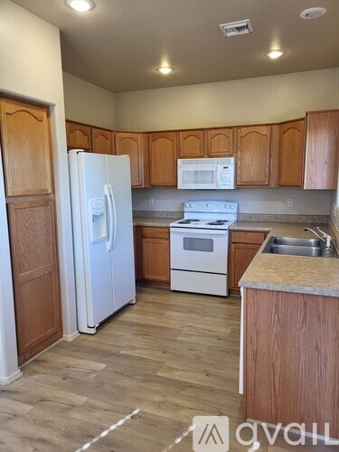 A kitchen with wooden cabinets and a white refrigerator.