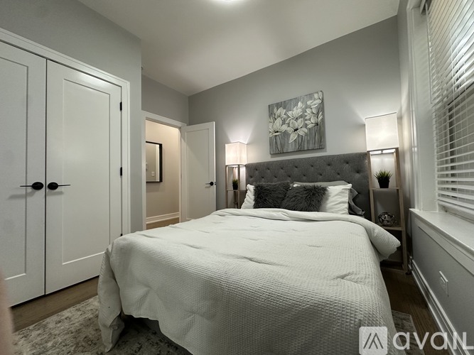 A bedroom with a large bed and a painting on the wall.