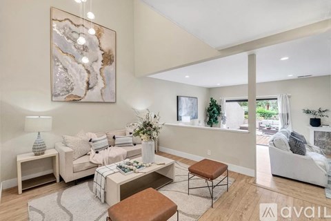 A living room with a large painting on the wall and a white couch.