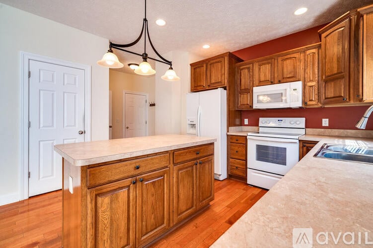 A kitchen with wooden cabinets and a white island.