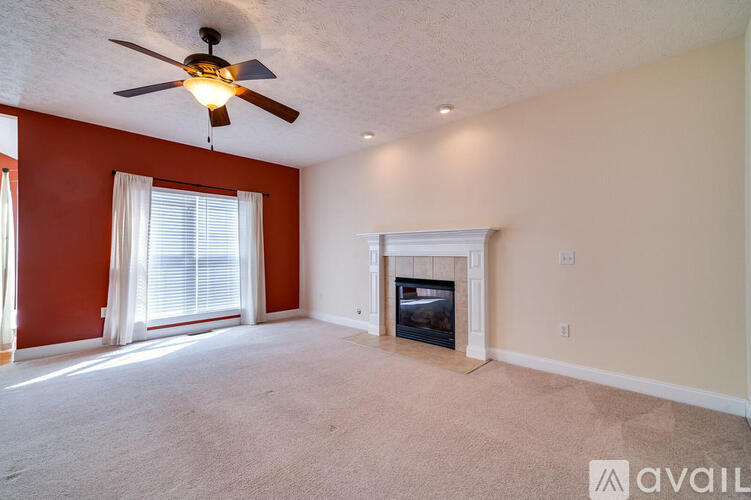 A living room with a fireplace and a ceiling fan.