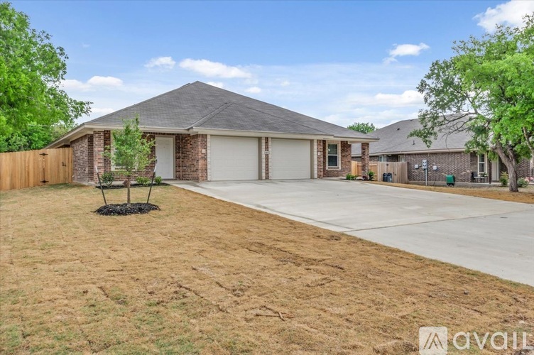 A house with a brown roof and a driveway in front.