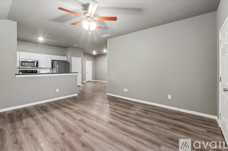 A spacious room with a ceiling fan and wooden flooring.