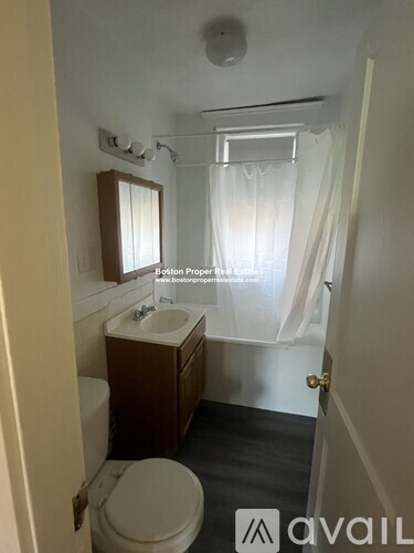 A small bathroom with a toilet, sink, and shower.