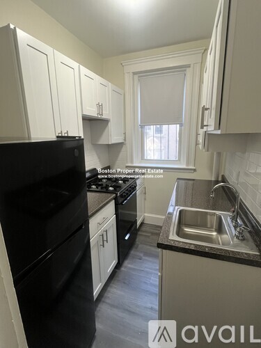 A kitchen with a black fridge and a window.