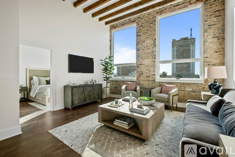 A living room with a large window and a flat screen TV mounted on the wall.