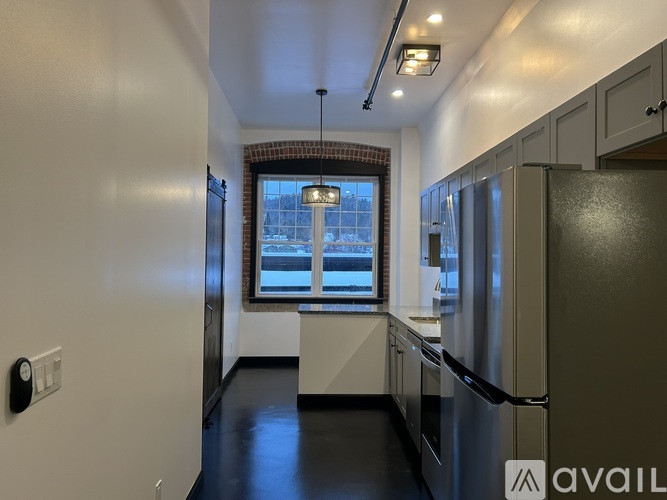 A kitchen with a refrigerator, sink, and cabinets.