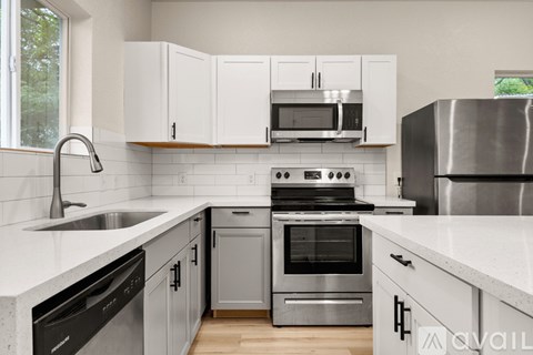 A kitchen with white cabinets and stainless steel appliances.