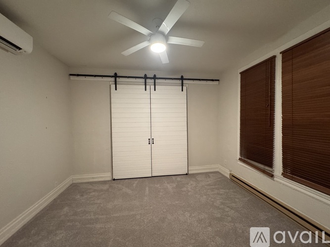 A room with a ceiling fan and a sliding door.