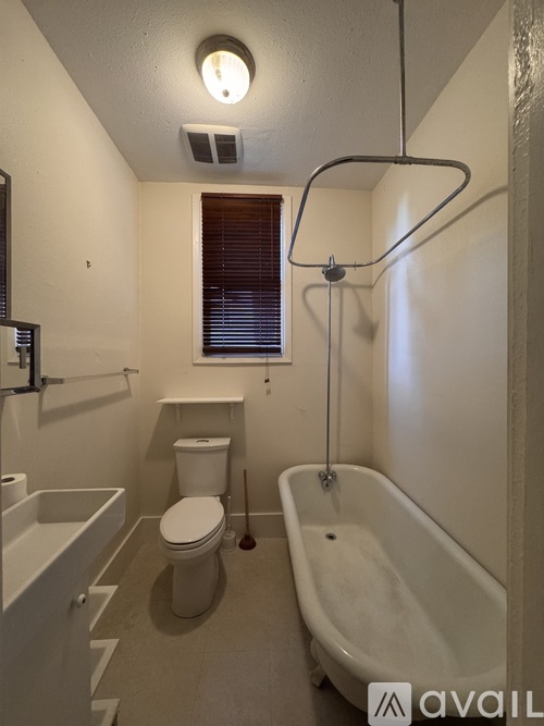A white bathroom with a toilet, sink, and bathtub.