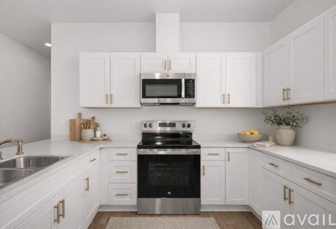 A modern kitchen with white cabinets and stainless steel appliances.