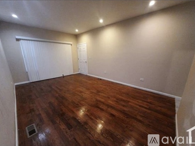A room with wooden flooring and white walls.