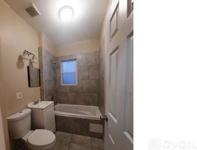 A bathroom with a toilet, sink, and bathtub.