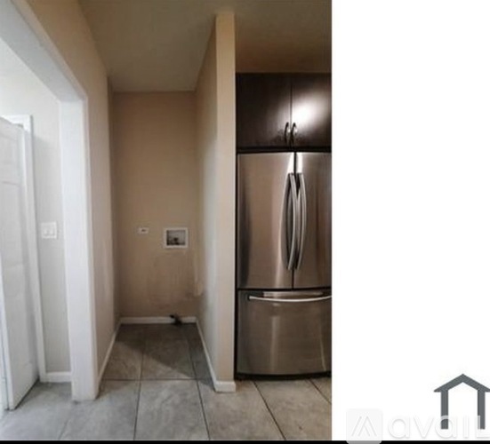 A kitchen with a stainless steel refrigerator and a white door.