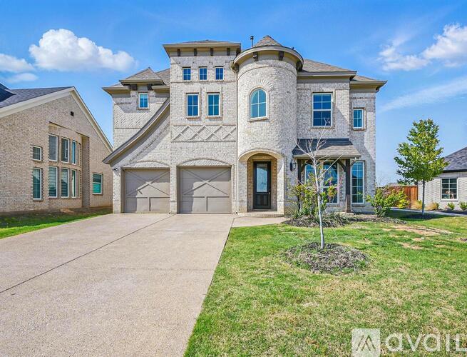 A large house with a driveway and a tree in front.