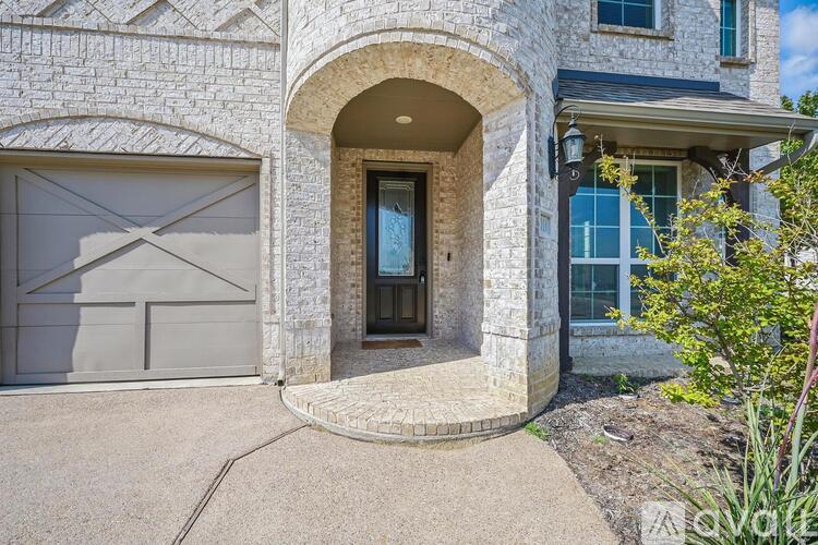 A house with a stone facade and a large arched entrance.