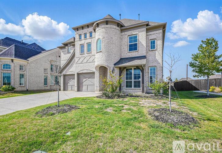 A large, two-story house with a stone exterior and a large front yard.