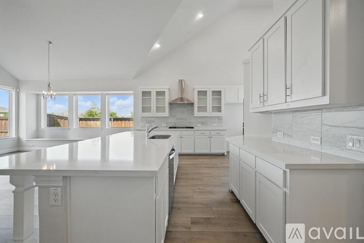 A modern kitchen with white cabinets and a large island.
