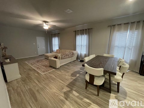 A living room with a dining table and chairs.