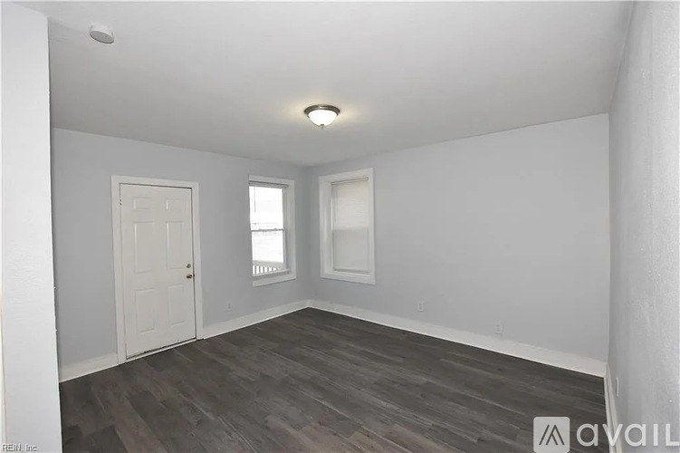 A room with a wooden floor and white walls.