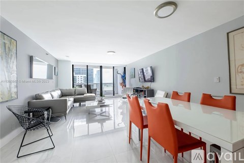 A modern living room with a glass table and orange chairs.