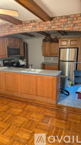 A kitchen with wooden cabinets and a brick wall.