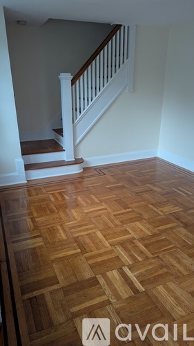A wooden floor with a staircase in the background.