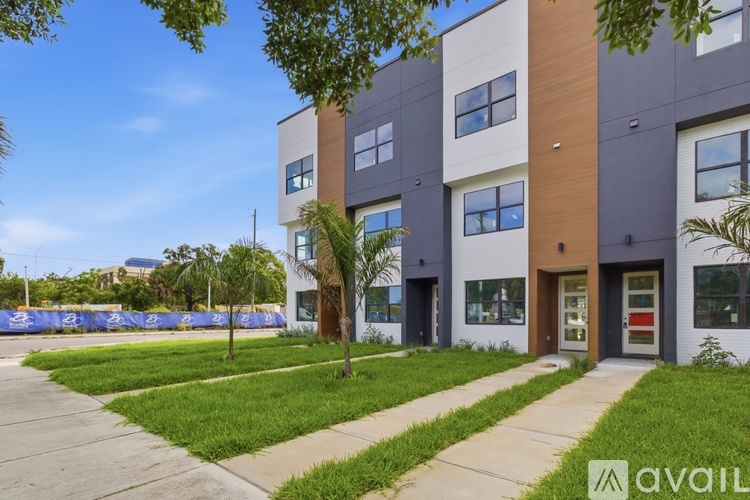 A modern apartment building with a blue tarp in the background.
