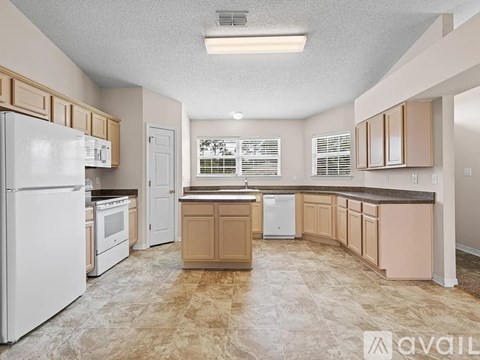 A kitchen with white appliances and wooden cabinets.