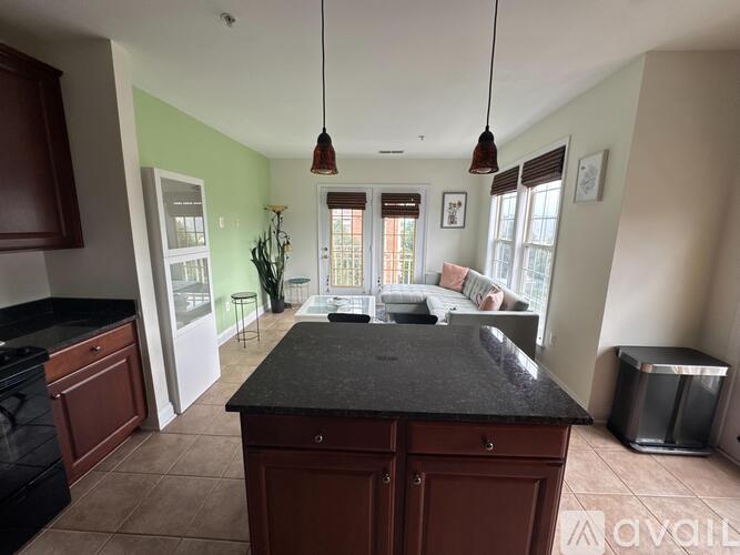 A kitchen with a black countertop and brown cabinets.