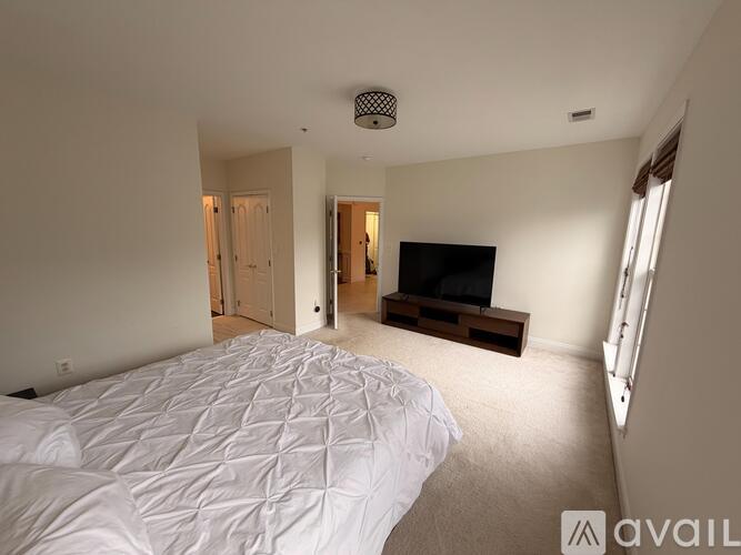 A bedroom with a large bed and a television in the corner.