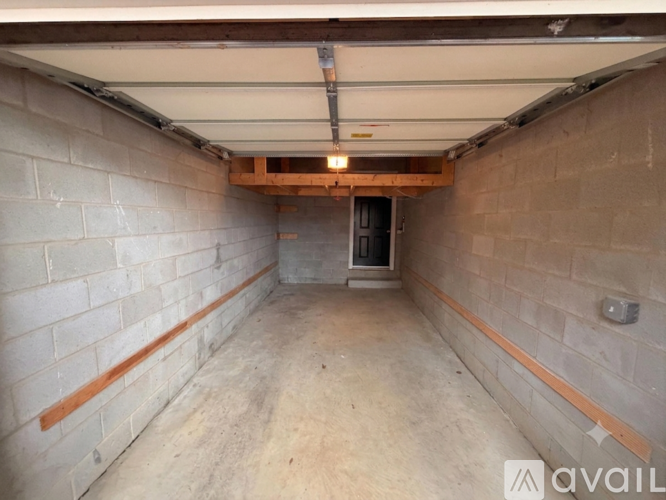 A spacious garage with a concrete floor and brick walls.