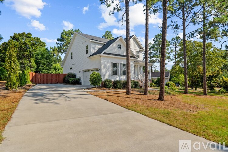A white house with a driveway in front of it.