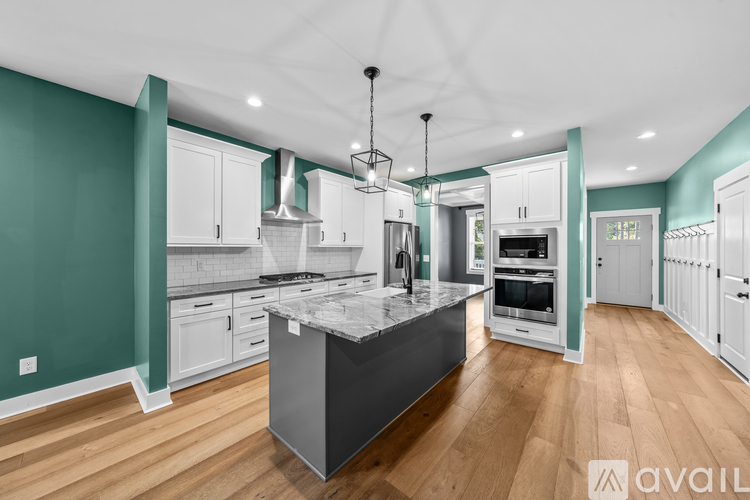 A modern kitchen with a center island and pendant lights.