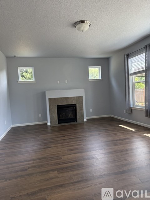 A living room with a fireplace and wood flooring.