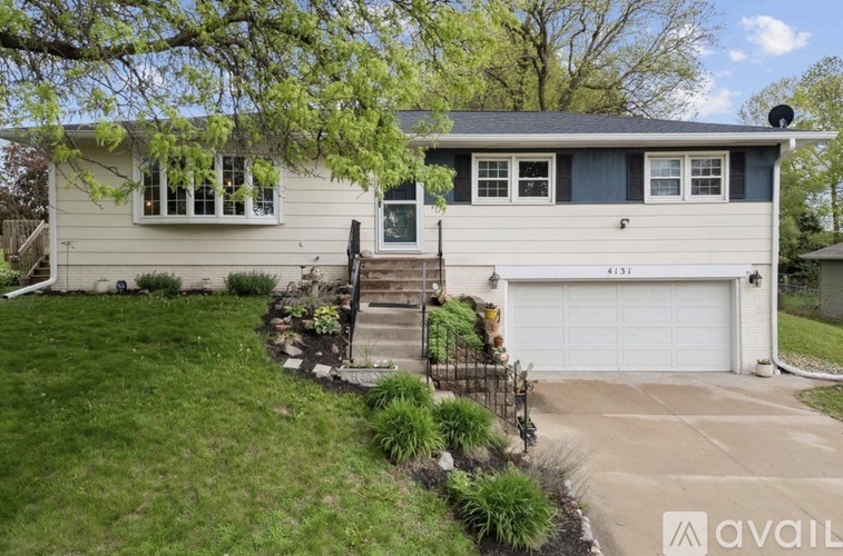 A house with a garage and a front yard with a staircase leading to the front door.
